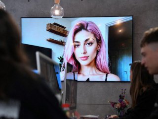 Образ на модела Айтана Лопес, генериран от изкуствен интелект, показан на екран в централата на компанията The Clueless © AFP / PAU BARRENA