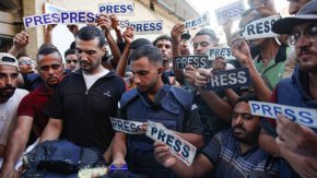 Оплаквачи и колеги с надписи "преса" обграждат тялото на журналиста от Al-Jazeera Arabic Исмаил ал-Гул, убит заедно с оператора си Рами ал-Рефи при израелски удар по време на репортаж от бежанския лагер Ал-Шати в Газа, 31 юли 2024 г. © Omar AL-QATTAA / AFP